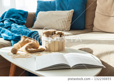 Knitting Setup with Yarn Basket, Book and Cozy Couch in Sunlight Knitting Setup with Yarn Basket, Book and Cozy Couch in Sunlight 132230855