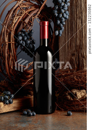 Bottle of red wine against the backdrop of an old weathered board, dried vine, and grapes. Bottle of red wine against the backdrop of an old weathered board, dried vine, and grapes. 132230862