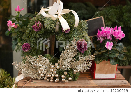 Christmas wreath made of fir branches and cyclamen in a pot Christmas wreath made of fir branches and cyclamen in a pot 132230969