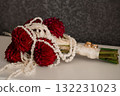 Wedding Bouquet with Red Dahlias and Pearl Necklace, Gold Rings, Romantic Still Life, Dark Background, Elegant Floral Arrangement, Celebration Symbolism. 132231023