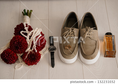 Wedding Day Essentials: Red Bouquet, Groom's Shoes, Watch and Cologne Flat Lay, Rustic Style, Warm Tones, Romance, Preparation Details Wedding Day Essentials: Red Bouquet, Groom's Shoes, Watch and Cologne Flat Lay, Rustic Style, Warm Tones, Romance, Preparation Details 132231032