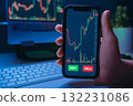 Trader hand holding smartphone with stock market or crypto trading app on screen 132231086