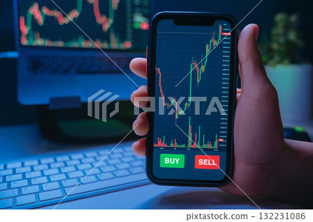 Trader hand holding smartphone with stock market or crypto trading app on screen Trader hand holding smartphone with stock market or crypto trading app on screen 132231086