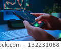 Trader hands using mobile trading app at night, buying crypto or stocks 132231088