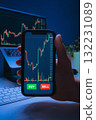 Close-up of trader hand holding phone with cryptocurrency or stock market app 132231089