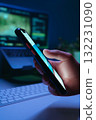 Close-up of hand holds smartphone and scrolling through social media in dark 132231090
