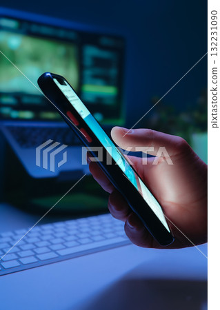 Close-up of hand holds smartphone and scrolling through social media in dark Close-up of hand holds smartphone and scrolling through social media in dark 132231090