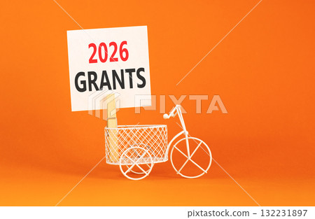 2026 Grants symbol. Concept words 2026 Grants on beautiful white paper on wooden clothespin. Beautiful orange background. Beautiful miniature bicycle. Business and 2026 grants concept. Copy space. 132231897