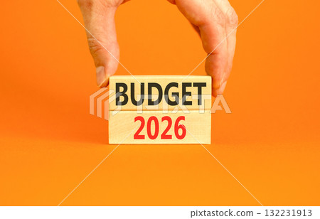 Budget 2026 symbol. Concept words Budget 2026 on beautiful wooden blocks. Beautiful orange paper background. Businessman's hand. Business and budget 2026 concept. Copy space. Budget 2026 symbol. Concept words Budget 2026 on beautiful wooden blocks. Beautiful orange paper background. Businessman's hand. Business and budget 2026 concept. Copy space. 132231913