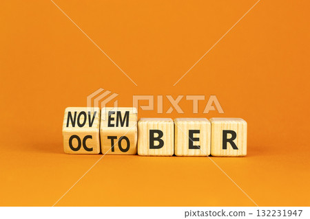 Symbol for the change from October to November. Businessman turns wooden cubes and changes the word October to November. Beautiful orange background. Happy November concept. Copy space. Symbol for the change from October to November. Businessman turns wooden cubes and changes the word October to November. Beautiful orange background. Happy November concept. Copy space. 132231947