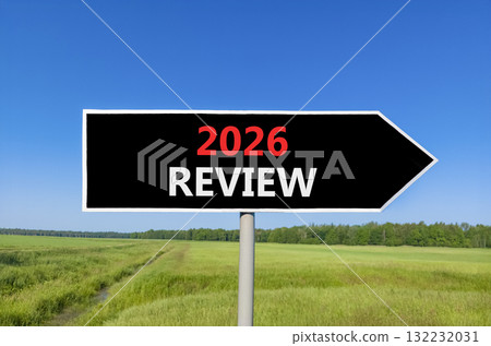 2026 Review symbol. Concept words 2026 Review on beautiful black road sign. Beautiful green grass field forest and blue sky background. Business and 2026 review concept. Copy space. 132232031