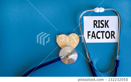Risk factor symbol. Concept words Risk factor on beautiful white card. Wooden heart and stethoscope. Beautiful blue background. Medical healthy lifestyle risk factor concept. 132232058
