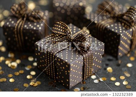 Decoratively Wrapped Presents With Golden Bows and Confetti on a Festive Table Decoratively Wrapped Presents With Golden Bows and Confetti on a Festive Table 132232389
