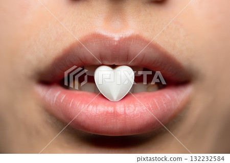 Sweet medicine heart-shaped pill resting on sensual female lips, romantic healthcare and treatment concept 132232584