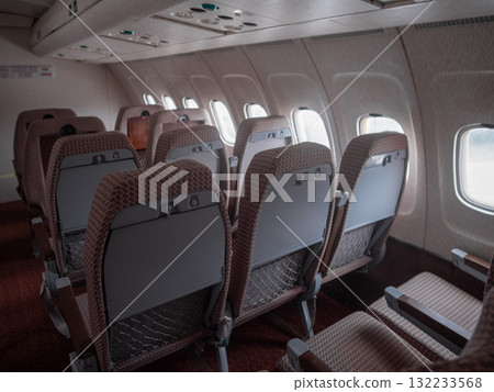 empty airplane seatback with folded tray and storage pocket, close perspective highlights material texture, ergonomic lines, tablet space and practical stowage features for product or safety 132233568