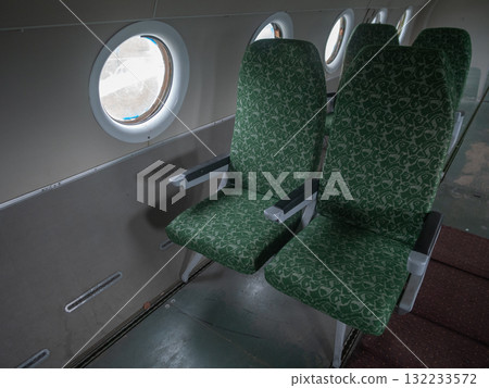 fabric details examined, detailed inspection of old upholstery fabric and armrest for repair, thorough examination of weathered green fabric on seat and armrest for restoration planning 132233572