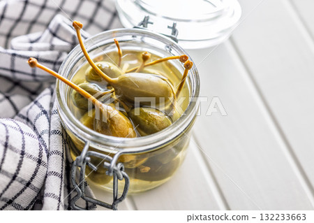 Pickled capers berries in bowl on white table 132233663