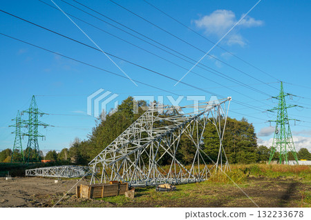 Steel framework of a new power transmission tower under construction beside existing green pylons Steel framework of a new power transmission tower under construction beside existing green pylons 132233678