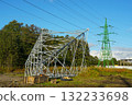 New power transmission tower under construction with metal framework and green pylon on sunny day 132233698