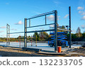 Steel frame structure and scissor lift at construction site under clear blue sky 132233705
