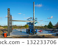 Steel frame structure under construction with scissor lift on building site against blue sky 132233706