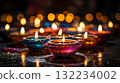 Candle light Diya oil lamps and colorful bokeh background. A colorful candles and flowers with a warm and inviting Diwali mood. 132234002