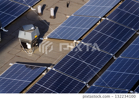 Solar panels on roof of apartment housing building, renewable green sustainable energy concept, water cooling, aerial view 132234100