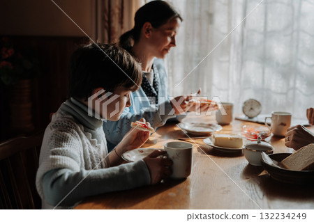 Family having simple meal together, eating bread with jam. Family having simple meal together, eating bread with jam. 132234249