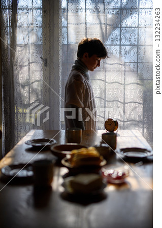 Poor sad young girl standing in old kitchen. 132234263