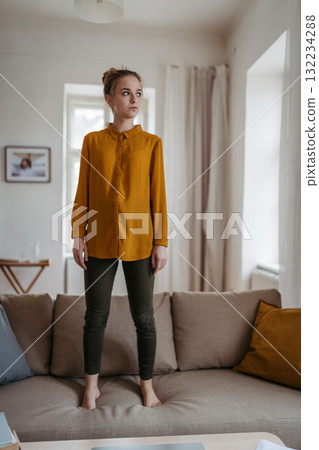 Depressed woman standing on sofa. Depressed woman standing on sofa. 132234288