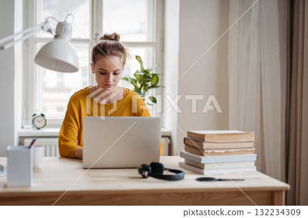 Young female student sitting at the table and studying. Young female student sitting at the table and studying. 132234309