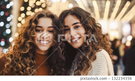 Two beautiful women with curly hair smiling at the camera. The girls with long, curly brown hair, smiling with joy. They are standing close together This is AI-generated item Two beautiful women with curly hair smiling at the camera. The girls with long, curly brown hair, smiling with joy. They are standing close together This is AI-generated item 132234356