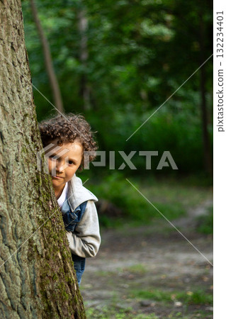 Curious Boy Exploring Nature in Park. 10 year old boy exploring something. His focused expression captures wonder of childhood discovery and learning about the natural world. High quality Curious Boy Exploring Nature in Park. 10 year old boy exploring something. His focused expression captures wonder of childhood discovery and learning about the natural world. High quality 132234401