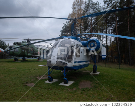old helicopter exhibit, rustic vintage helicopter outside, antique helicopter displayed outdoors among trees, weathered vintage helicopter showcased in outdoor rustic environment among trees 132234539
