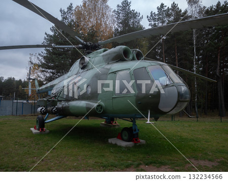 helicopter cockpit inspection, technician checks helicopter instruments, detailed view of helicopter nose showing technician inspecting instrument panel amidst reflections and camouflage 132234566