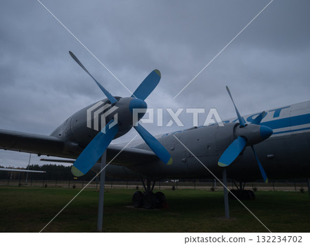 heavy transport triple blue propellers parked under brooding sky, massive fuselage and multiple hubs emphasize scale and engineering, static museum context with rugged metal texture heavy transport triple blue propellers parked under brooding sky, massive fuselage and multiple hubs emphasize scale and engineering, static museum context with rugged metal texture 132234702
