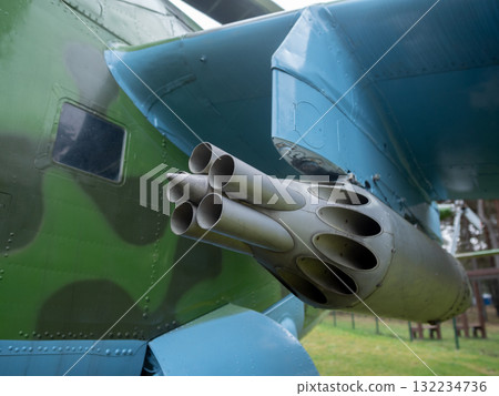 closeup of rocket tubes mounted on camouflaged fuselage emphasizes circular openings and chipped paint, low angle shows mounting rack and grassy display setting, evocative of military closeup of rocket tubes mounted on camouflaged fuselage emphasizes circular openings and chipped paint, low angle shows mounting rack and grassy display setting, evocative of military 132234736