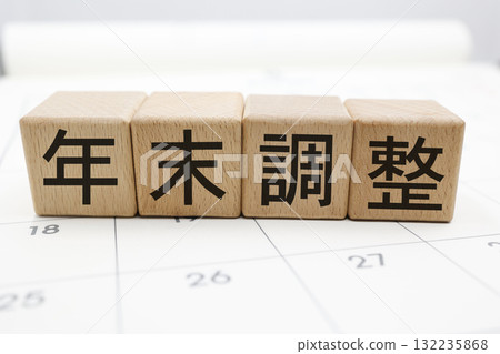 帶有木塊和文字“年終調整”的日曆背景。 帶有木塊和文字“年終調整”的日曆背景。 132235868
