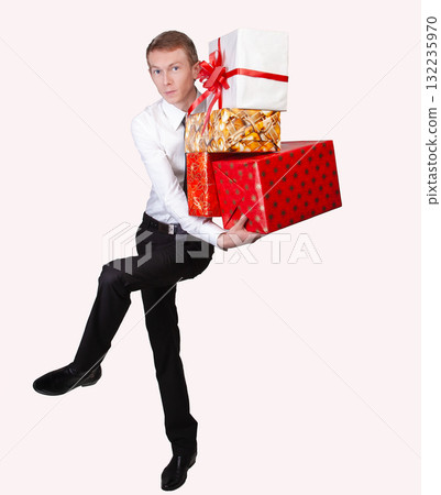 Man in dress shirt and tie is holding multiple colorful gift boxes, representing celebrations, holidays, or generosity. 132235970
