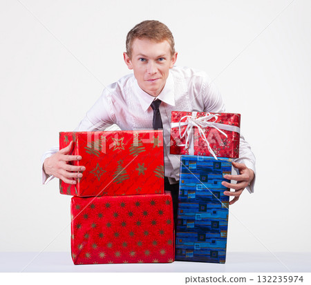 Man in dress shirt and tie is holding multiple colorful gift boxes, representing celebrations, holidays, or generosity. 132235974
