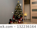 Beautiful Christmas tree decorated with golden ornaments, lights, and a shining star topper. Festive gnome toys placed around the base create a cozy and joyful holiday atmosphere at home 132236164