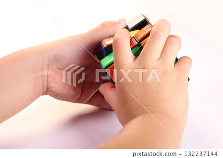 Child's hands playing with a Rubik's Cube 132237144