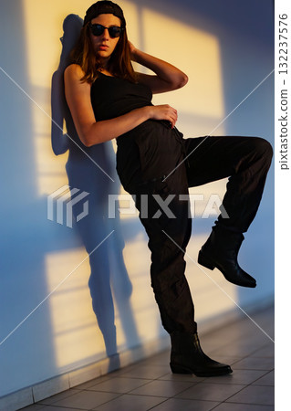 Teenage model posing in urban sunset, ideal for fashion photography and youth lifestyle ads. 132237576