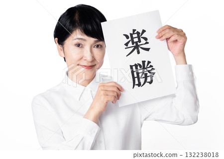 一位身穿白襯衫的老年婦女手裡拿著一張寫著「輕鬆取勝」的紙，目光轉向別處 132238018