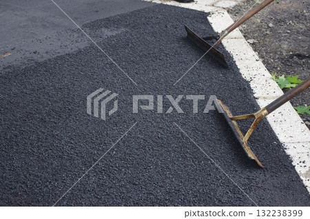Two shovels are laying on a black surface Two shovels are laying on a black surface 132238399
