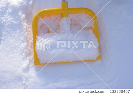 Yellow snow shovel is sitting in the snow 132238407