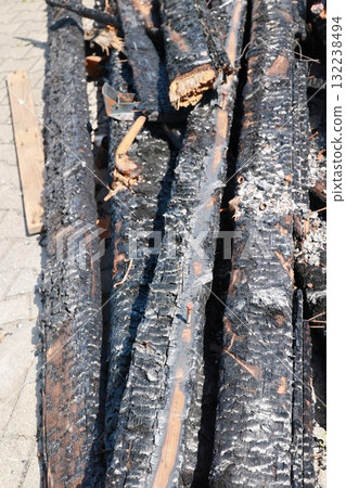 A pile of burnt wood with a greyish-black color A pile of burnt wood with a greyish-black color 132238494