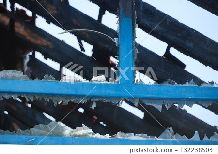 A blue roof with black shingles and a broken window A blue roof with black shingles and a broken window 132238503