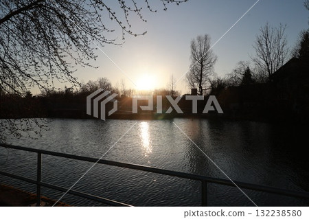 A calm lake with a fence on the side A calm lake with a fence on the side 132238580