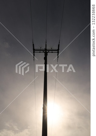 A tall power pole with three wires on top 132238668